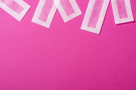 top view of wax depilation stripes on pink background