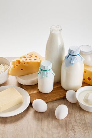 various fresh organic dairy products and eggs on wooden table isolated on whiteの写真素材
