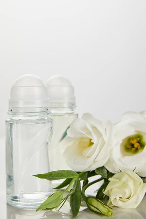 roll on bottles of deodorant with roses isolated on whiteの写真素材