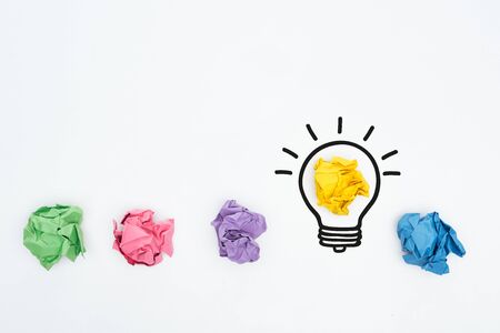 top view of colorful crumpled paper balls and illustration of light bulb, business concept
