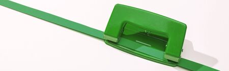 panoramic shot of holepunch and paper strip on white backgroundの写真素材