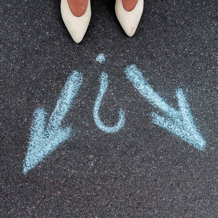 top view of woman standing near blue directional arrows on asphalt