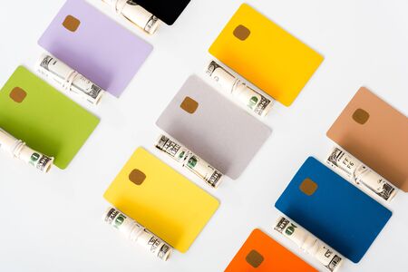 top view of credit card templates near cash rolls with dollar banknotes isolated on whiteの写真素材