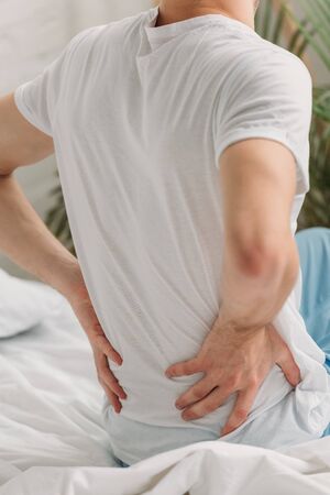 partial view of man touching loin while suffering from pain