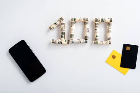 top view of smartphone with blank screen near cash rolls and credit card templates on whiteの写真素材