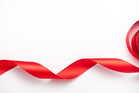 top view of curled and red ribbon on white with copy spaceの写真素材
