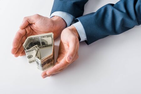 cropped view of businessman near heart-shaped dollar banknotes on whiteの写真素材