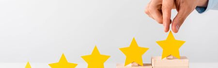 panoramic shot of man touching yellow star isolated on whiteの写真素材
