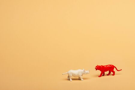 Toy rhinoceros and tiger on yellow background, animal welfare conceptの写真素材