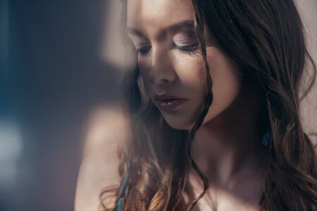 tender young bohemian woman with braids on gray