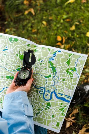cropped view of woman holding map and vintage compass outsideの写真素材