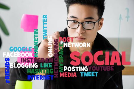 asian seo manager writing on glass with illustration of concept words of social media