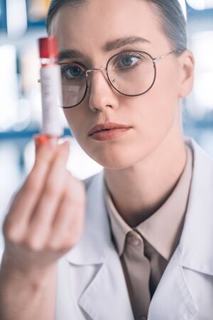 selective focus of attractive allergist in glasses holding test tubeの写真素材