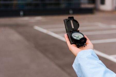cropped view of woman holding retro compass outsideの写真素材