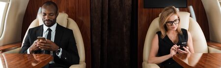panoramic shot of handsome african american businessman and attractive businesswoman using...