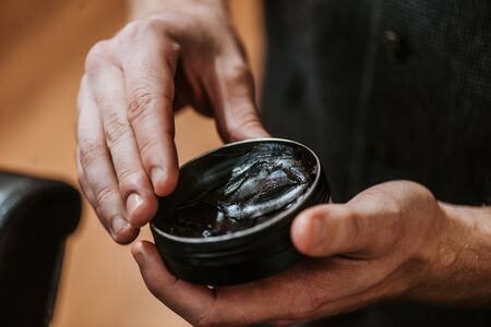 cropped view of man holding jar with black hair pomadeの写真素材