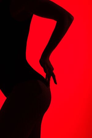 black silhouette of sexy buttocks of passionate woman, isolated on redの写真素材