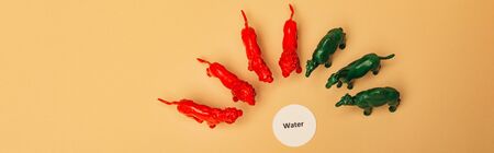 Panoramic shot of toy animals with lettering water on card on yellow background, water scarcity...