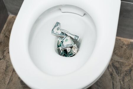 top view of dollar banknotes in toilet bowl in modern restroomの写真素材