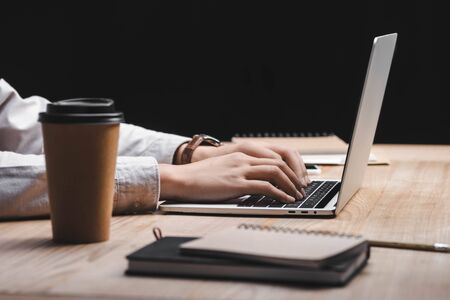 cropped view of seo manager sitting at table and using laptop 