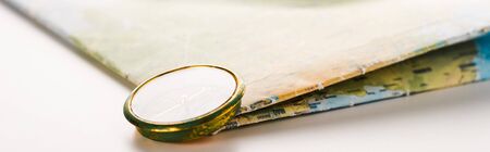 panoramic shot of golden compass near map on white
