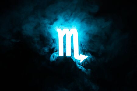 blue illuminated Scorpio zodiac sign with smoke on backgroundの写真素材
