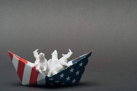 Toy animals in paper boat from american flag on grey background, animal welfare conceptの写真素材