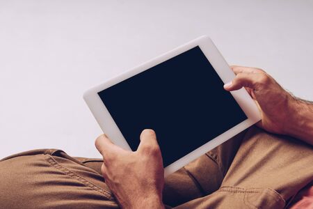 partial view of man using digital tablet with blank screen isolated on greyの写真素材
