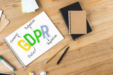 top view of paper with gdpr lettering, notebooks, paper cup, pen, pencil, sticky notes, marker and...