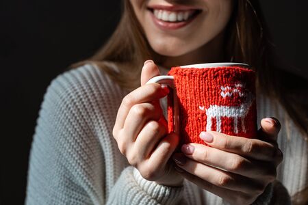 cropped view of smiling woman holding christmas cup of coffeeの写真素材