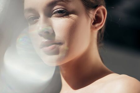 portrait of attractive nude girl on grey with lens flaresの写真素材