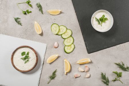 Top view of tzatziki sauce on boards with ingredients on stone backgroundの写真素材