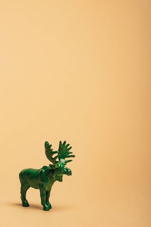Green toy moose on yellow background, animal welfare conceptの写真素材