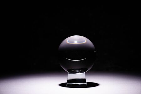 crystal ball on white surface on black background