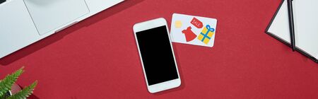 top view of credit card on red background with smartphone, laptop, notepad, panoramic shotの写真素材