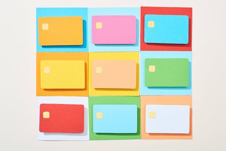 top view of multicolored empty credit cards on grey background