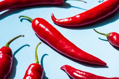 Close up view of ripe chili peppers on blue background