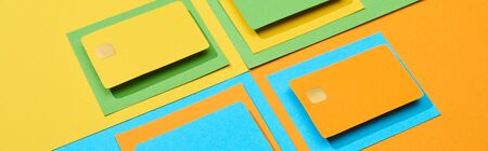 empty credit cards on green, orange, blue and yellow background, panoramic shotの写真素材