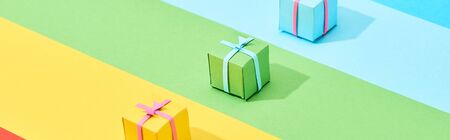 multicolored gift boxes on rainbow background, panoramic shotの写真素材