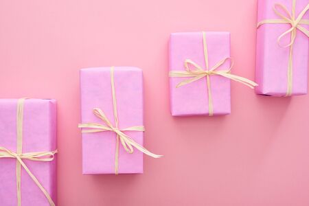 top view of wrapped presents with bows on pink 