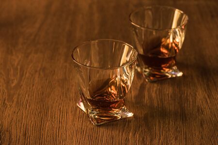 Two glasses of brandy on wooden table