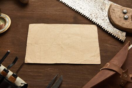 aged carpentry tools near blank vintage notebook on wooden table