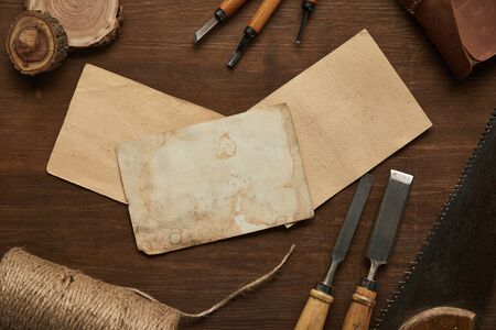 top view of aged carpentry tools near blank vintage papers on wooden tableの写真素材
