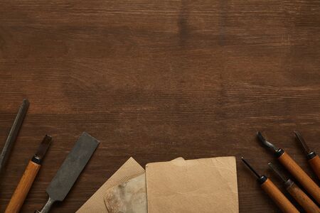 top view of aged carpentry tools near blank vintage papers on wooden table
