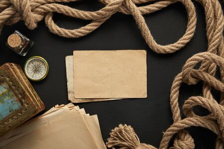 top view of vintage paper, rope, compass and painting on black backgroundの写真素材