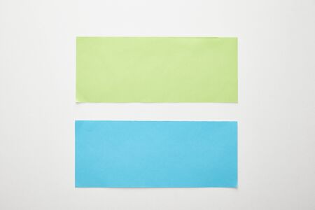 top view of empty blue and green paper on white background