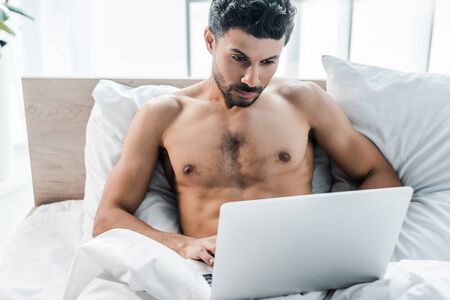 handsome and sexy bi-racial man using laptop in morningの写真素材