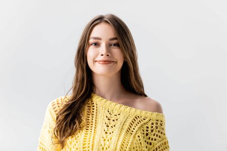 attractive girl in yellow sweater smiling at camera isolated on greyの写真素材