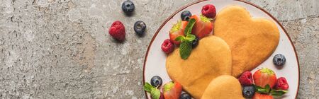 top view of heart shaped pancakes with berries on grey concrete surface, panoramic shotの写真素材
