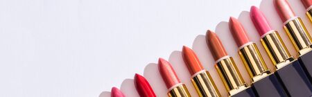 top view of assorted lipsticks in luxury tubes in line on white background, panoramic shotの写真素材